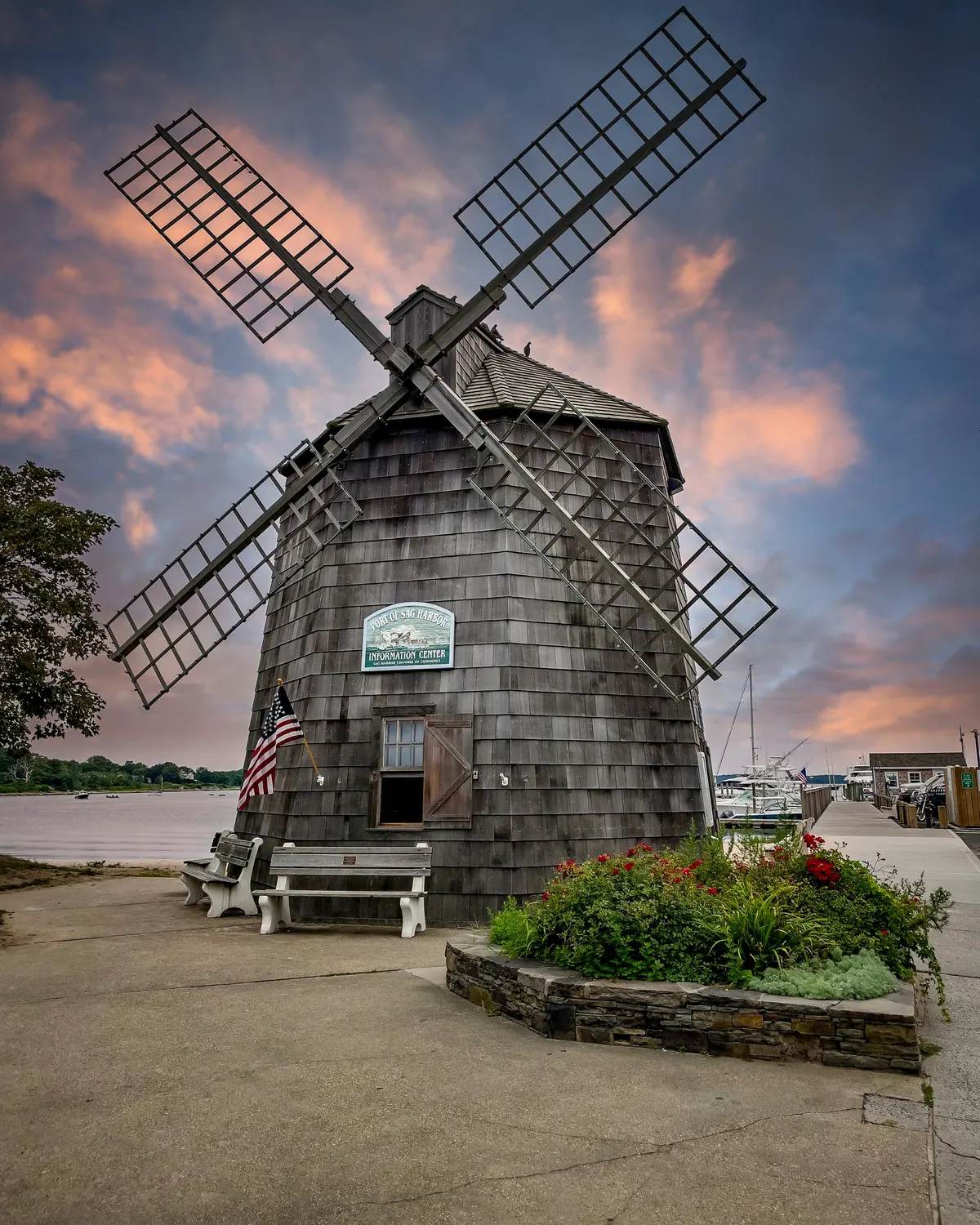 A traditional shingled windmill on the East End under an evening sky
