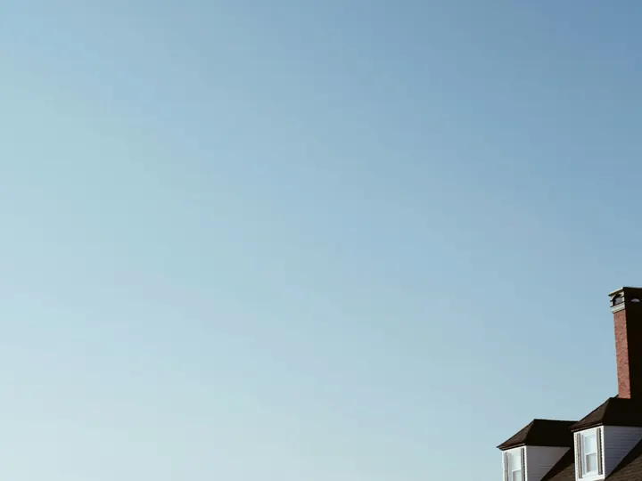 A white clapboard house above the water