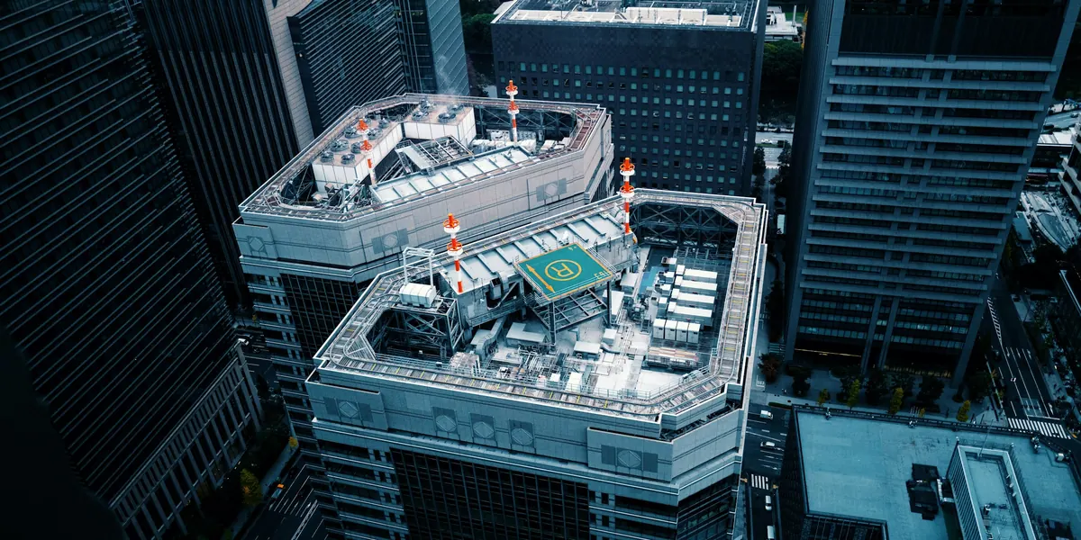A rooftop helipad among city towers, seen from above